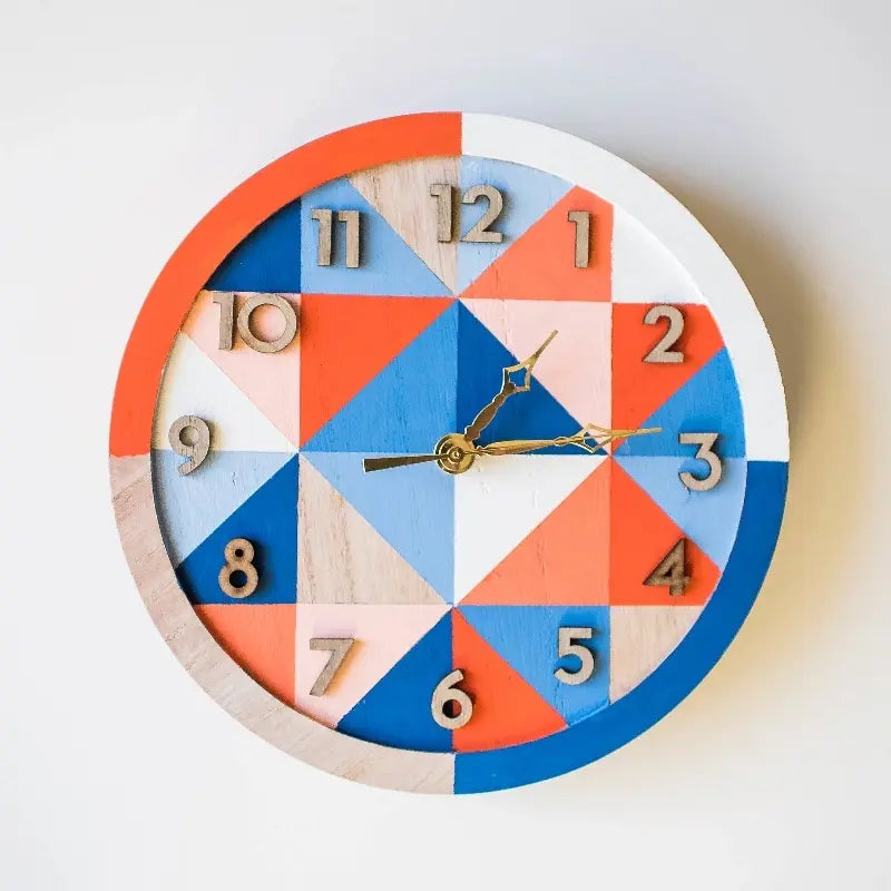 An artistic wooden clock made up of an orange and blue triangle pattern
