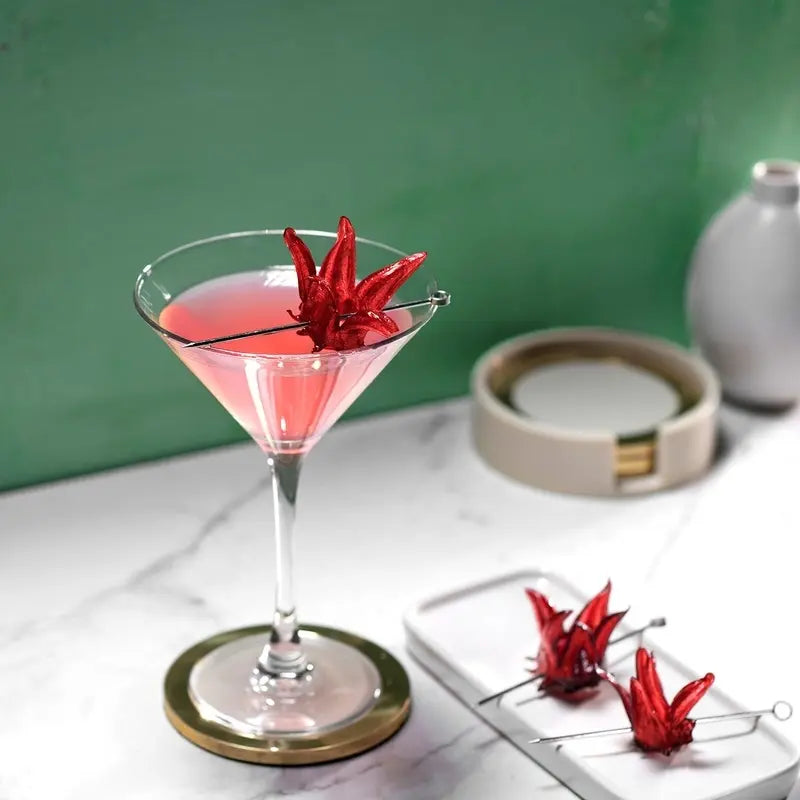 A pink martini with a red flower on a white marble table